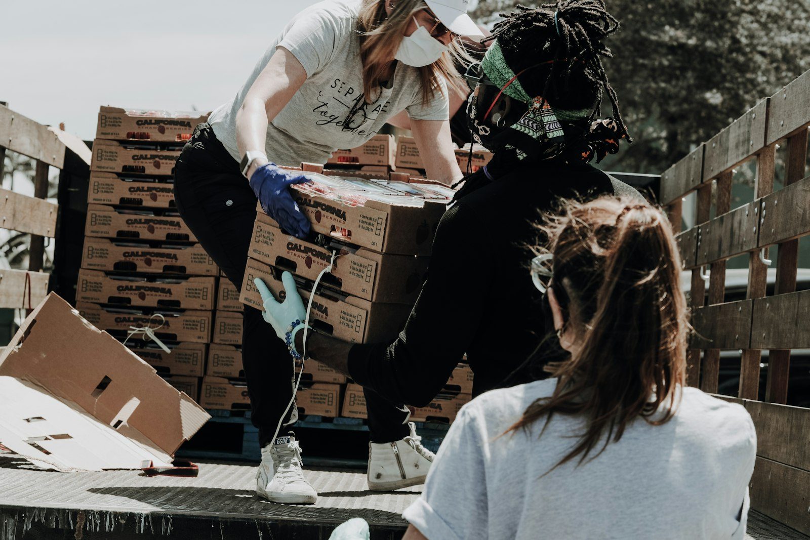 Volunteers smiling while packing meal boxes for neighbors in need